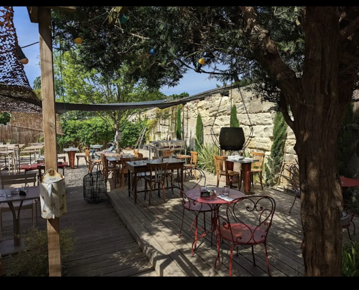 Tables de jardin sous le grand pin, contre le mur de pierre